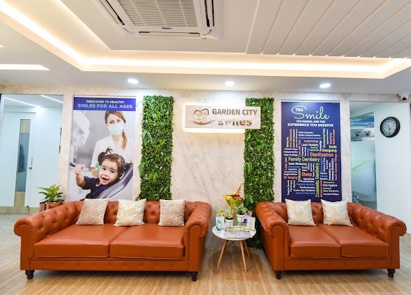 GardenCity Smiles Dental Clinic lounge with two sofas and clinic signage