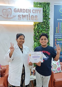 A young visitor and clinician holding a certificate at the clinic