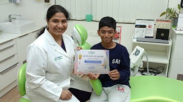 A young visitor and clinician with a certificate in the treatment room